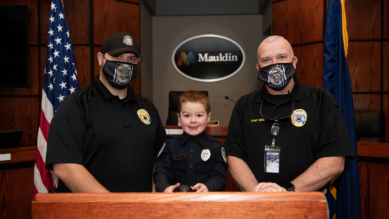 Bennett smiles with Officer James Madden and Chief Miller from Mauldin Police Department