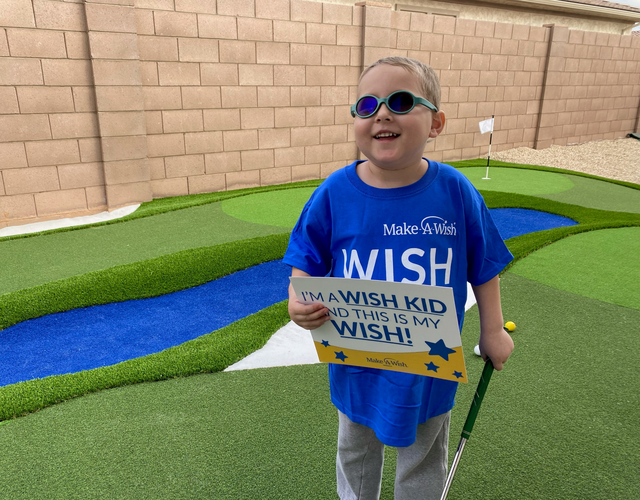 Wish kid Andrew in backyard standing in front of his new golf course