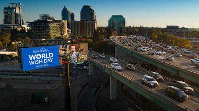 Make-A-Wish billboard overlooking city landscape