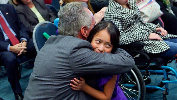 Joe Plumeri and wish child embrace at the Wishing Place Grand Opening