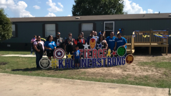 Khonner and the Motorcycle Club posing by a #KhonnerStrong yard sign.