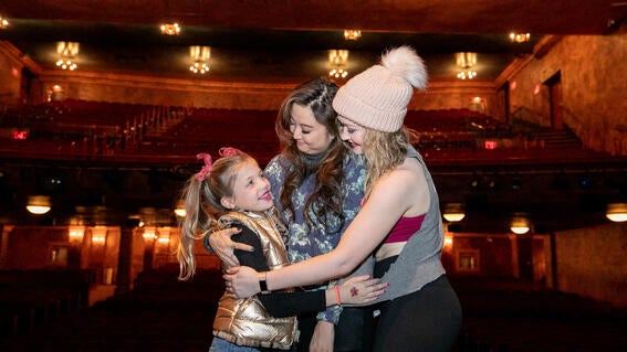 Wish kid Palmer hugs cast members Ashley Park and Devon Hadsell