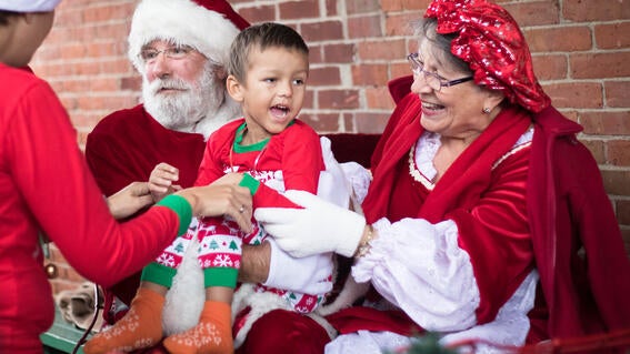 Santa and Mrs. Claus hold four-year-old Michael in their sleigh
