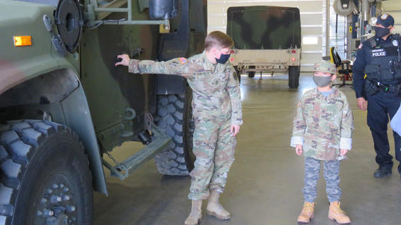 Soldiers show Miguel their work vehicles