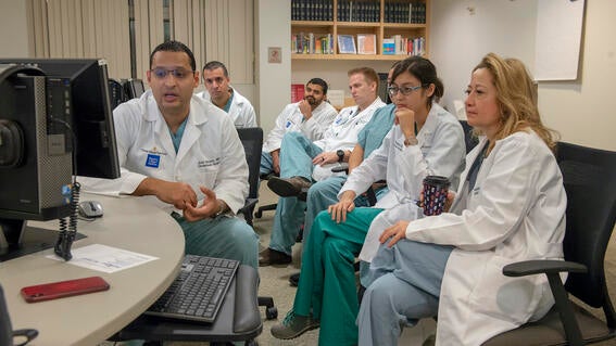 Wish kid Micaela sitting around a screen with doctors