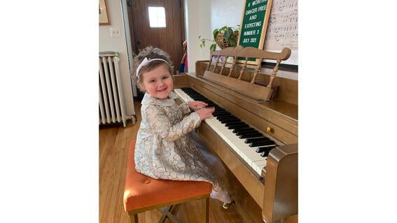Wish kid Lydia playing the piano dressed up for wishes