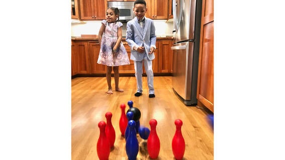 Kids MIa & RJ bowling in their kitchen while dressed up for wishes