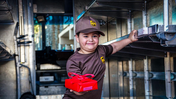 Mateo in a UPS truck with a red package in his hand