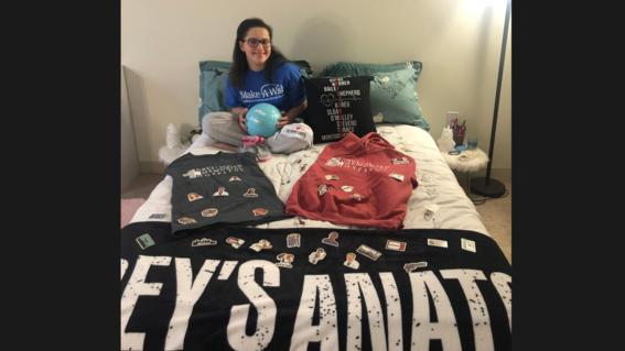 Photo of Giulia sitting on her bed at home surrounded by Grey's Anatomy items