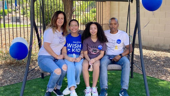 Kylie and her family on bench swing in backyard.