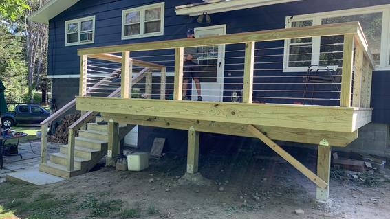 A brand new deck comes off the back of a blue house