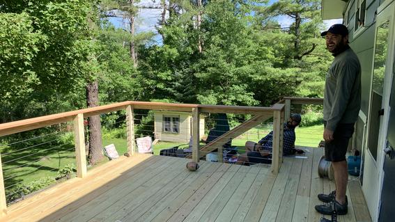 Man smiles out at newly constructed deck.