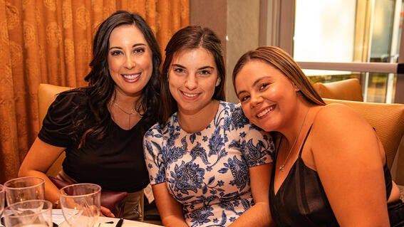 Three guests enjoying wine and food at the event. 