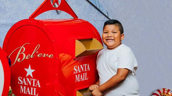 Wish kid Pastor drops his letter in the Believe mailbox at Macy's