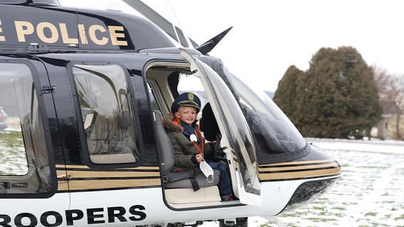 Landen sits inside a police helicopter.