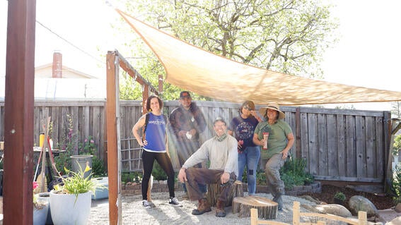 Staff and volunteers who helped with Yahya's wish pose in the backyard