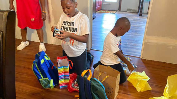 Kayden and his brother opening gifts. Kayden is on the left and has a surprised look finding out his wish is granted