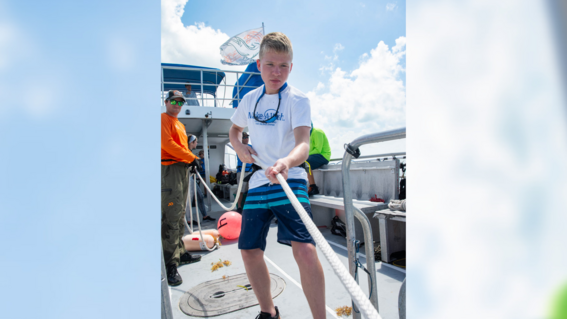 Cole reeling in a shark to take measurements