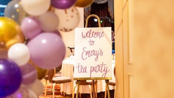 Emery's entrance to her high tea, a sign and balloon arch.