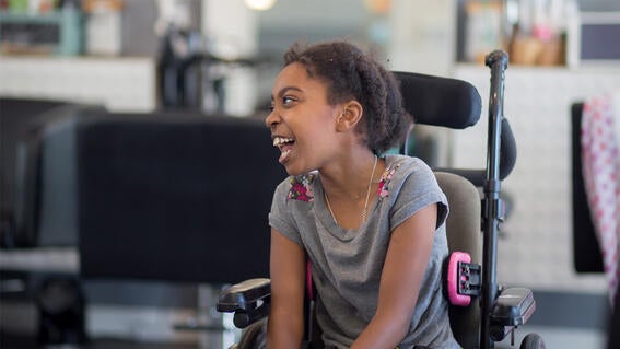 Tatiana smiles while seated in her wheelchair