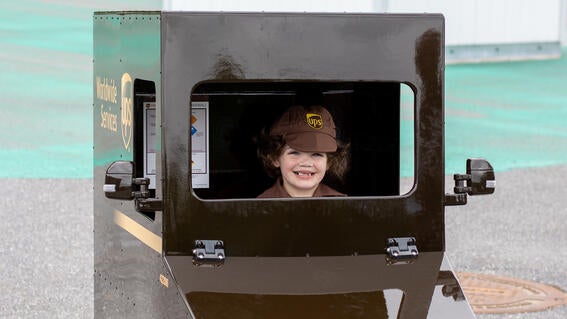 JoJo in his UPS uniform driving his mini UPS delivery truck