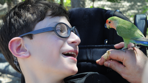Nikita smiling at a colorful bird