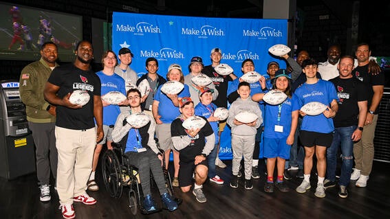wish kids celebrating at dave & buster's with signed footballs