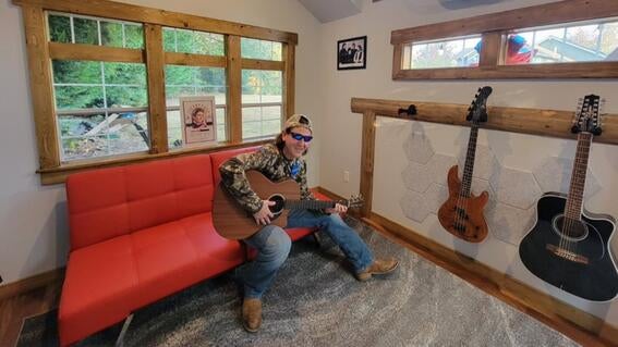 Billy playing guitar in his new studio shed