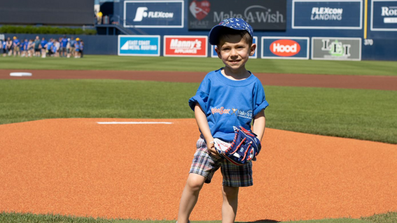 Wish Community child throwing first pitch at WooSox game