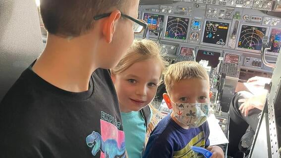 Brayden and his siblings in the cockpit of their plane, on route to Brayden's wish
