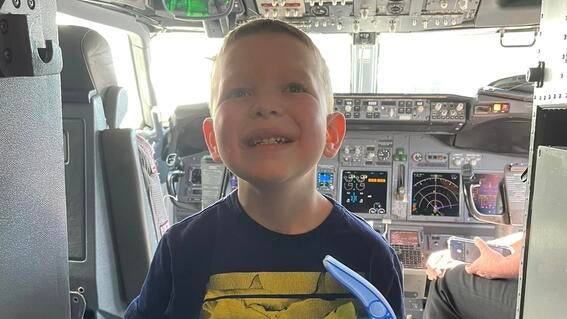 holding a toy in the cockpit of the plane, on route to the wish