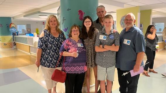 Addison and her family smile in the hospital hallway