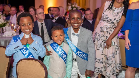 Wish kids Isaiah, Dakota and Cameron sharing big smiles at Wish Ball