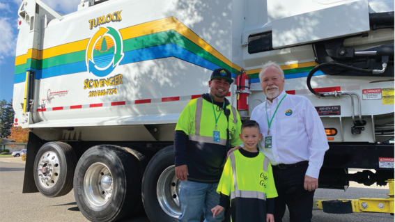 Carter and City Wide Property Services (sponsor) member smile in front of the Turlock Scavenger garbage truck
