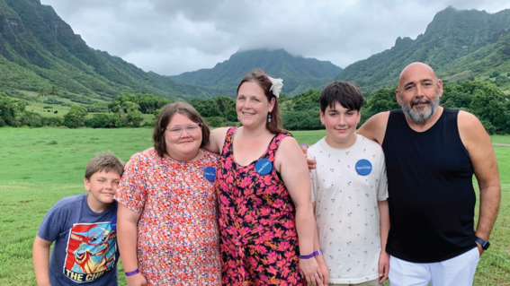 Rusha and her family in front of a beautiful Hawaiian landscape