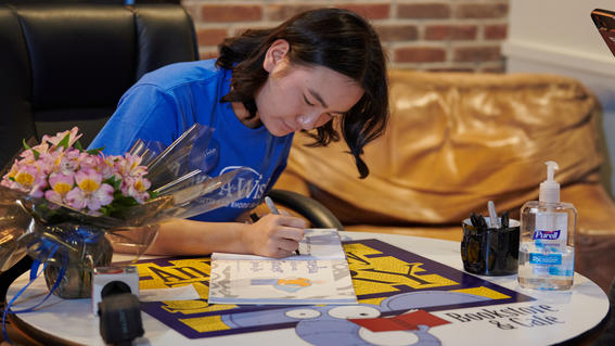 Amelia signs a book at her book launch party