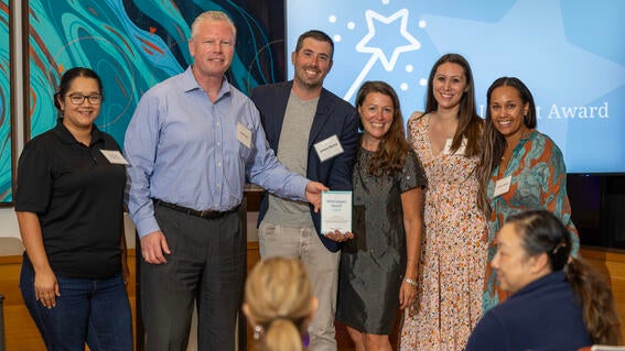 CEO Betsy Biern awarding Del Grande Dealer Group CEO Jeremy Beaver and staff the Wish Impact Award.