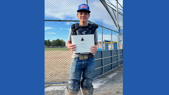 Miles holding his athletic certificate after receiving the 2023 season award on his baseball team.