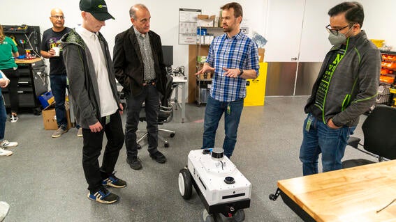 Luca enjoying a live robotics demo with NVIDIA staff in the demo room and robotics lab.