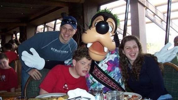 Alex with Goofy and siblings at Disney World