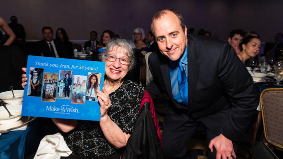 Jean holding her 35-year volunteer milestone plaque with Senior Volunteer Manager Daniel at the 2023 Evening of Wishes gala, Wishes by Design.