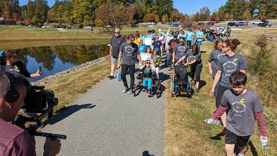 Wish kid Marcy pictured front center walking in her pink Trexo with a large group following behind her