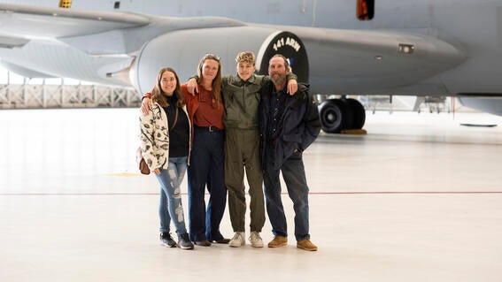 Wish Kid Isaiah and family standing in front of an airplane outdoors