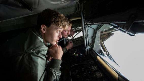 Isaiah and pilot instructor looking through windshield from the inside of an airplane cockpit