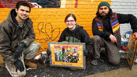 Josie and artists posing in front of their mural