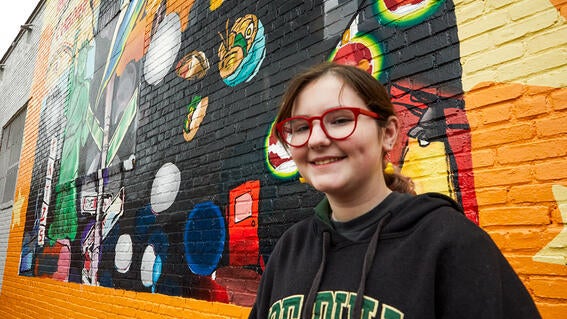 Josie posing in front of the mural