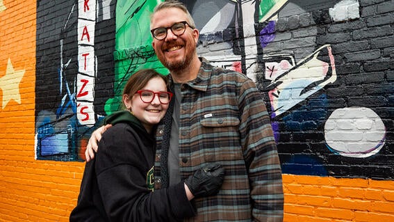Josie and father in front of mural