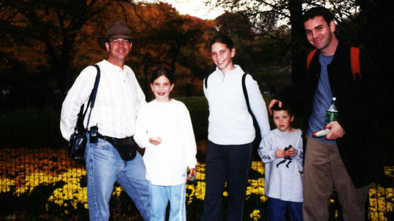 Matthew with his family in New York with trees in the background
