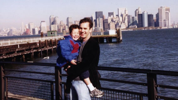 Matthew being held by his uncle Lucas with the New York city skyline in the background