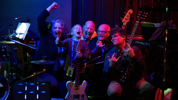 From left to right: Pianist and vocalist Helen Orzel, Nolan, Todd Tribble the drummer, Stuart Speering the bassist, and Morris Acevedo the guitarist during Nolan's wish to have a rock band experience.